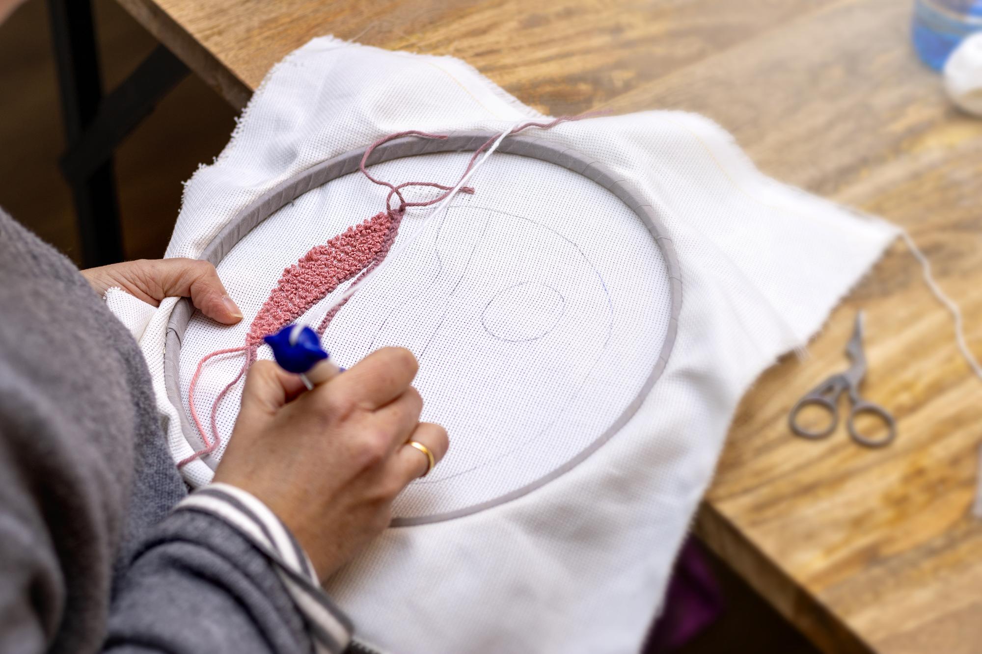 Hands finishing embroidery on hoop